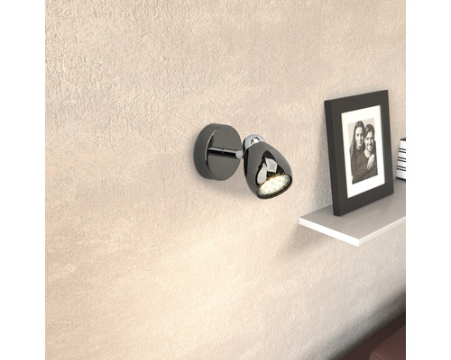 Applique murale noire avec lumière LED et tête réglable à côté d''une étagère