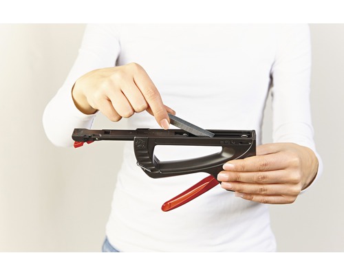 Une personne recharge une agrafeuse avec des agrafes.