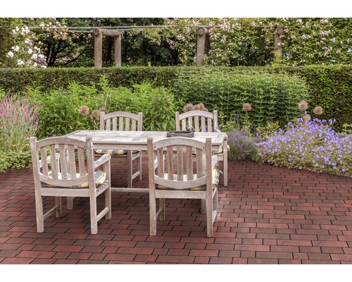 Scène de jardin avec table et chaises en bois sur pavés