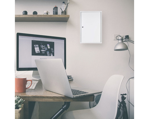 Arbeitszimmer mit Schreibtisch, Computer, Lampe und Schlüsselkasten an der Wand