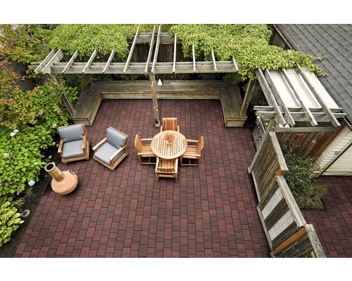Vue de dessus d''une terrasse avec des pavés, des meubles en bois, une pergola et des plantes vertes.