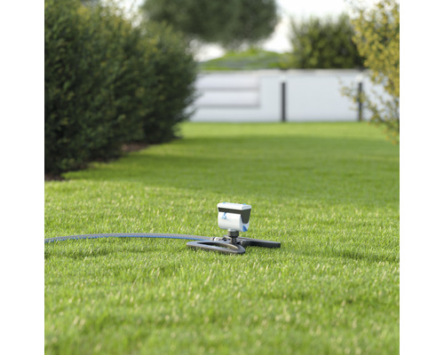 Rasensprenger mit Schlauch auf Rasenfläche