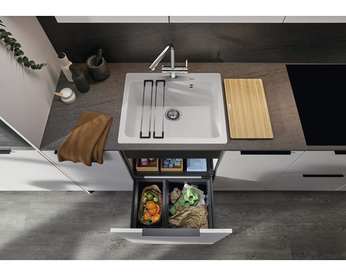 Évier de cuisine avec robinet, planche à découper et système de tri des déchets dans une cuisine moderne