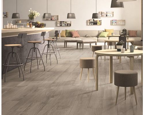 Innenraum mit Holzboden, Barhockern und Tischen.