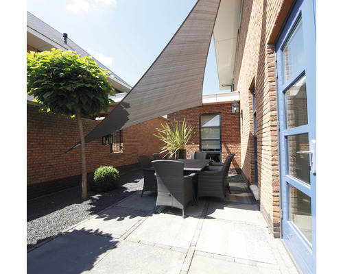 Gartenszene mit dreieckigem Sonnensegel über einer Gartengarnitur auf einer Terrasse.