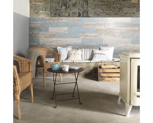 Salon avec panneaux muraux en bois, fauteuils en rotin, petite table et poêle