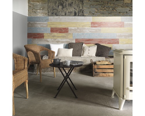 Kunststoffpaneel Element Compact Cabane natur 1200 x 154 x 6 mm Gemütlicher Wohnbereich mit Wandpaneelen in Holzoptik, Korbstühlen, einem runden Tisch und einem Ofen