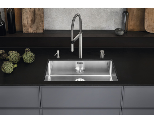 Évier en acier inoxydable avec robinetterie et distributeur de savon sur un comptoir de cuisine