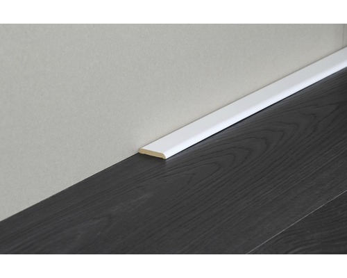 Sockelleiste aus Holz an dunklem Laminatboden