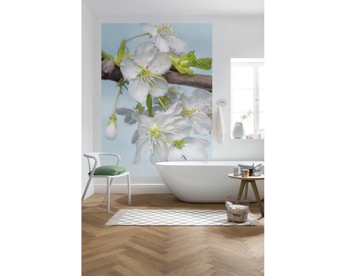 Salle de bains avec papier peint photo à motif floral, baignoire et plancher en bois.