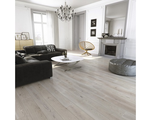 Salon lumineux avec canapé, table, fauteuil, cheminée et parquet