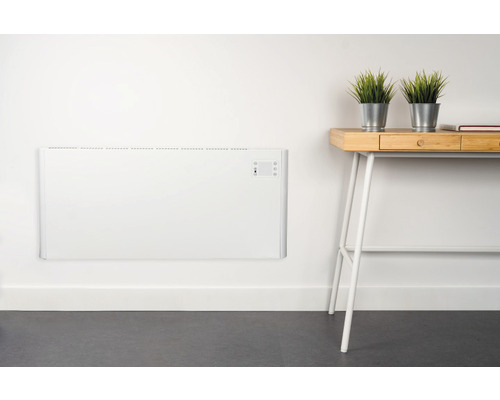 Radiateur convecteur mural dans une pièce avec bureau et décoration