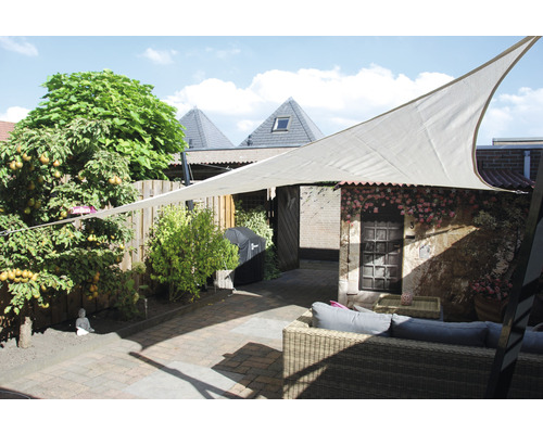 Voile d''ombrage au-dessus d''une terrasse avec mobilier de jardin et plantes