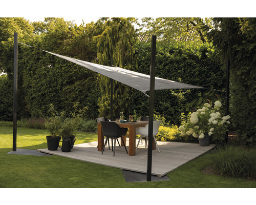 Scène de jardin avec voile d''ombrage, table à manger et chaises sur une terrasse en bois