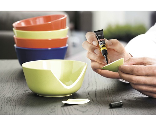 "Eine Person repariert eine zerbrochene Schüssel mit Klebstoff