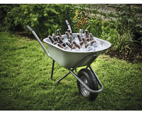 Brouette remplie de glace et de bouteilles de bière dans le jardin.