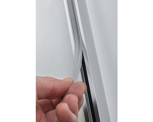 La main guide le profilé d''étanchéité dans un rail profilé en aluminium