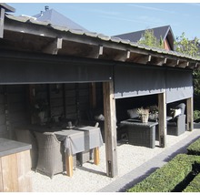 Überdachte Terrasse mit Rattanmöbeln und Rollo als Windschutz