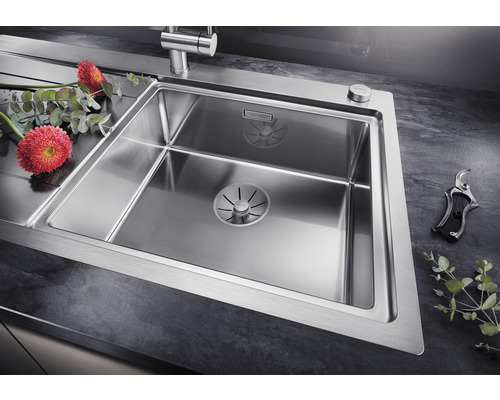 Edelstahlspüle mit Abtropffläche und Blumen auf einer Küchentheke