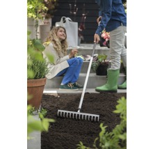 Scène de jardinage avec râteau et deux personnes