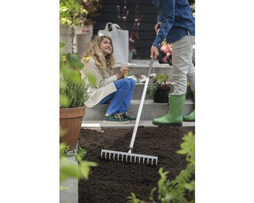 Scène de jardinage avec râteau et deux personnes