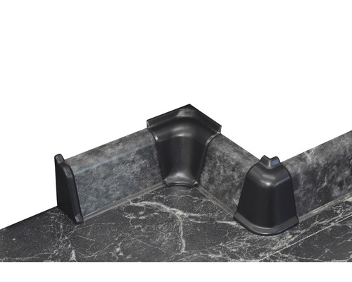 Trois coins en plastique noir sur un plan de travail.