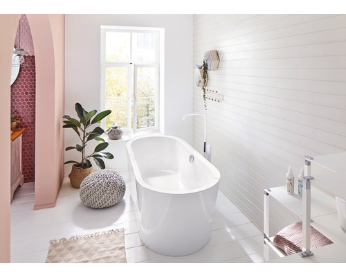 Helles Badezimmer mit freistehender Badewanne, Fenster und Dekorationen.