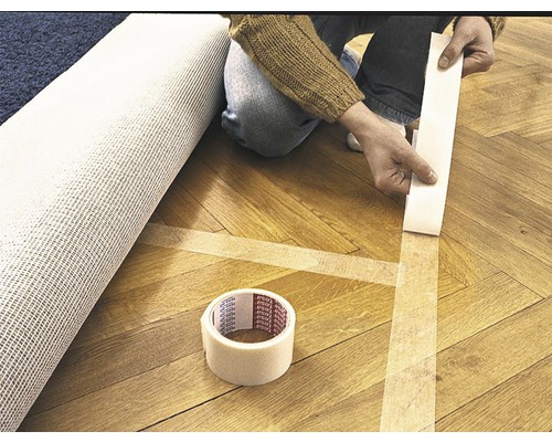 Fixation d''un tapis avec du ruban adhésif double face sur un plancher en bois