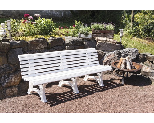 Aménagement paysager de jardin avec banc blanc, foyer et mur en pierre