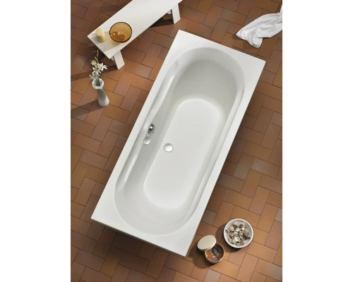 Photo d''une baignoire rectangulaire dans une salle de bains avec carrelage et accessoires de bain.