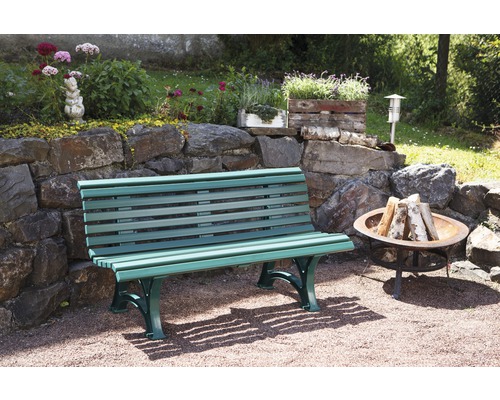 Scène de jardin avec un banc, un foyer et un mur de pierre avec des décorations