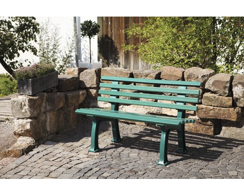 Banc de jardin vert en bois et mur de pierre à l''extérieur