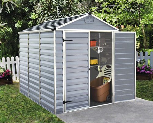 Graues Gerätehaus mit geöffneter Tür im Garten, darin ein Schubkarren und Regale