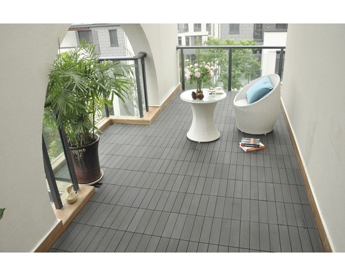 Balcon avec dalles de terrasse foncées, coin salon et plante