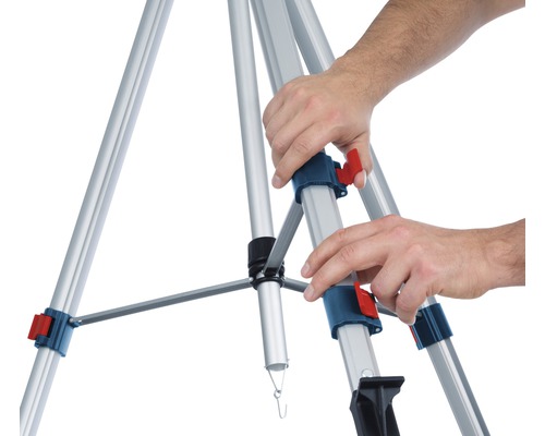 Person stellt einen Aluminium-Baustativ auf