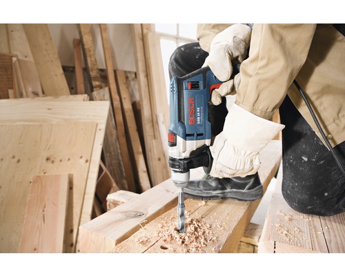 Bohrarbeiten mit einer Bosch Schlagbohrmaschine an einem Holzbalken