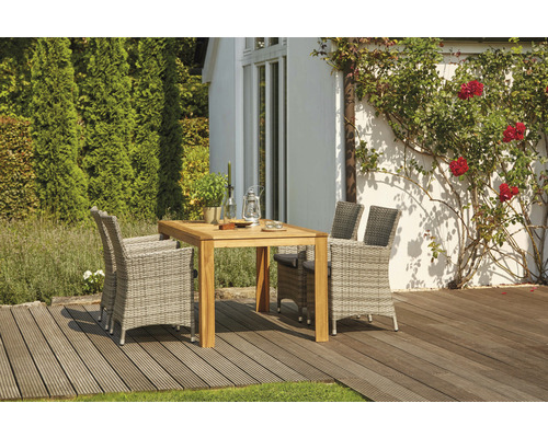 Gartenszene mit Holztisch und Rattansesseln auf einer Holzterrasse