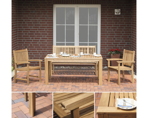 Gartensitzgruppe aus Teakholz mit Tisch, Bank und zwei Stühlen auf einer Terrasse vor einem Haus