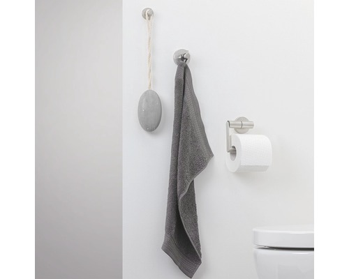 Badezimmerwand mit Haken, Handtuch, Toilettenpapierhalter und Bimsstein