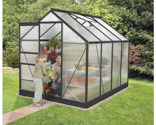 Gewächshaus mit einer Person und einem Kind, die Pflanzen einpflanzen