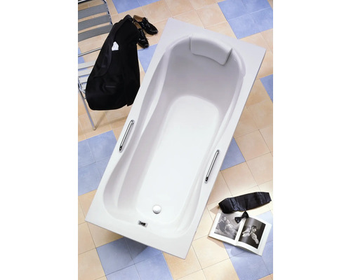 Baignoire blanche avec repose-tête et poignées dans la salle de bain.