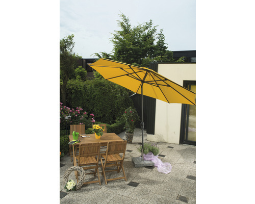 Gelber Sonnenschirm über einer Gartensitzgruppe aus Holz mit Tisch und Stühlen auf einer Terrasse