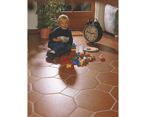 Enfant jouant avec des blocs de construction sur un sol en carreaux octogonaux