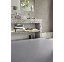 Salle de bains avec lavabo en pierre, serviettes et sol gris