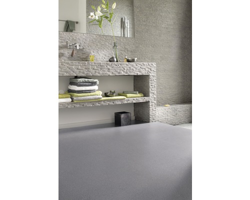 Salle de bains avec lavabo en pierre, serviettes et sol gris