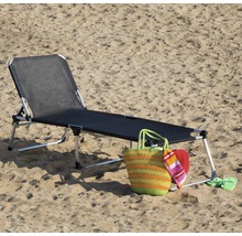 Chaise longue de plage avec sac de plage et accessoires dans le sable