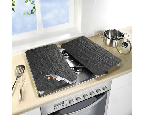 Plaques de recouvrement de cuisinière en ardoise sur une cuisinière avec des ustensiles de cuisine et un couteau