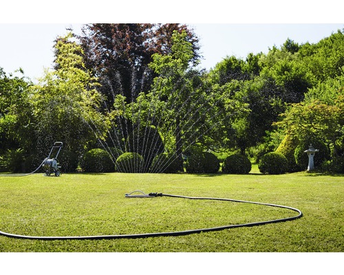 Gartenbewässerung mit Rasensprenger und Schlauchwagen