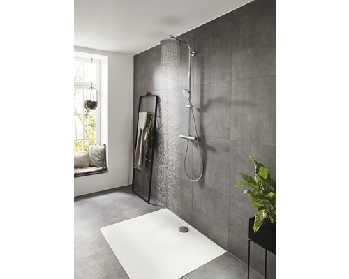 Scène de douche avec receveur de douche, robinetterie de douche et porte-serviettes dans la salle de bains