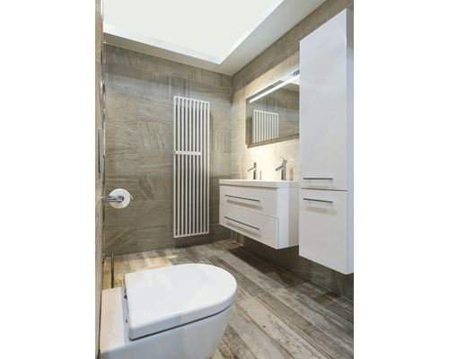 Modernes Badezimmer mit Toilette, Waschtisch, Spiegel, Heizkörper und Fliesen